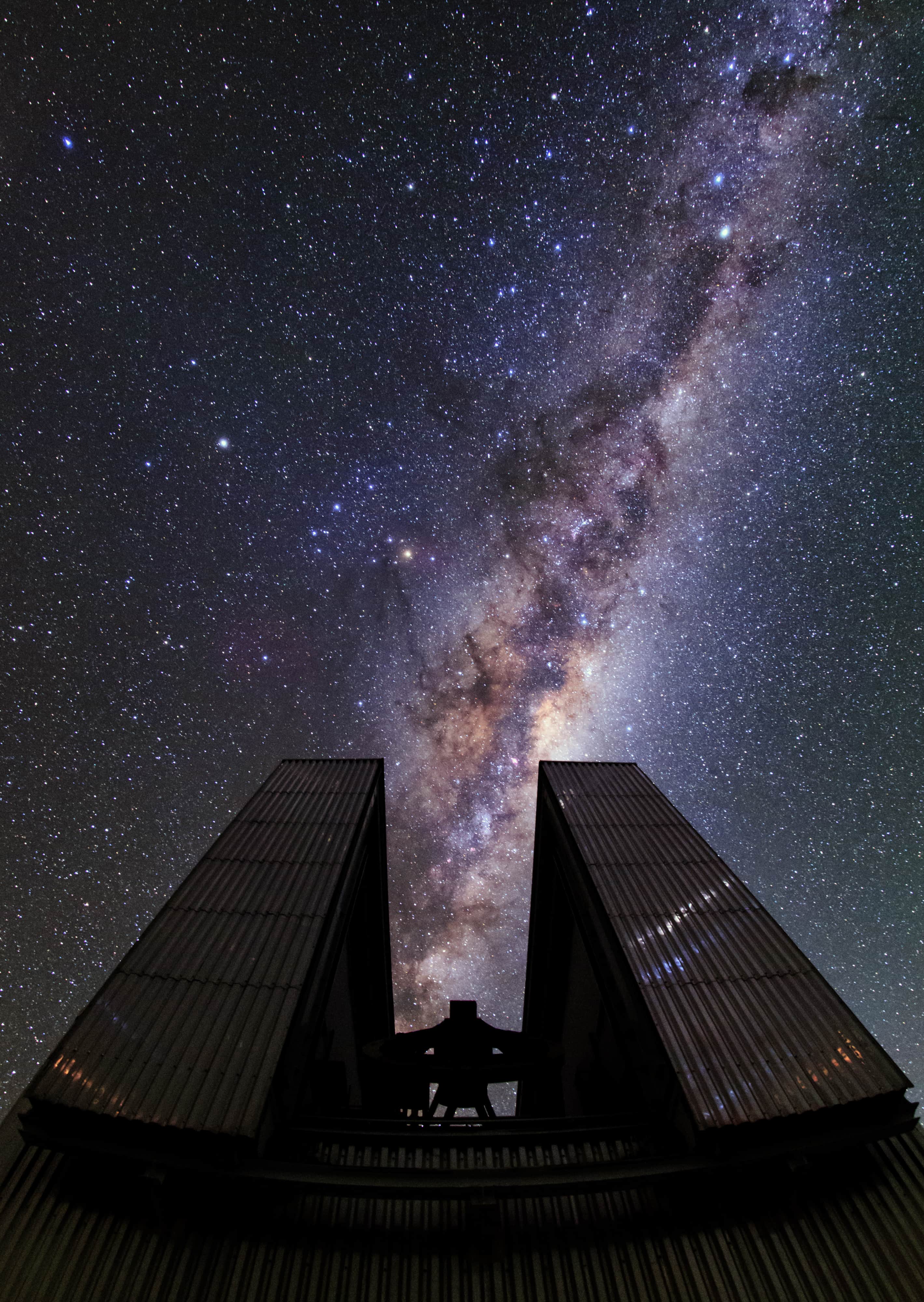 A curtain of stars surrounds the 3.58-metre New Technology Telescope (NTT) in this new Ultra High Definition photograph from the ESO Ultra HD Expedition [1]. It was captured on the first night of shooting at ESO's La Silla Observatory, which sits at 2400 metres above sea level on the outskirts of the Chilean Atacama Desert. The majestic telescope enclosure aligns perfectly with the Milky Way’s central region — the brightest section and the area which obscures the galactic centre. The distinctive octagonal enclosure that houses the NTT stands tall in this image — silhouetted against the glittering cosmos above and almost appearing to consume the Milky Way. This telescope housing was considered a technological breakthrough when completed in 1989. Visible to the left of the Milky Way is the bright orange star Antares at the heart of Scorpius (The Scorpion). Saturn can be seen as the brightest point to the upper left of Antares and Alpha and Beta Centauri glow in the upper right of the image. The Southern Cross (Crux) and the Coalsack dark nebula are also visible looming above Alpha and Beta Centauri. La Silla was ESO’s first observatory, inaugurated in 1969. The NTT pictured above was the first telescope in the world to have a computer-controlled main mirror and broke new ground for telescope engineering and design paving the way for ESO's Very Large Telescope. Notes [1] The team is made up of ESO's videographer Herbert Zodet, and three ESO Photo Ambassadors: Yuri Beletsky, Christoph Malin and Babak Tafreshi. Information on the expedition's technology partners can be found here, and their blog here.